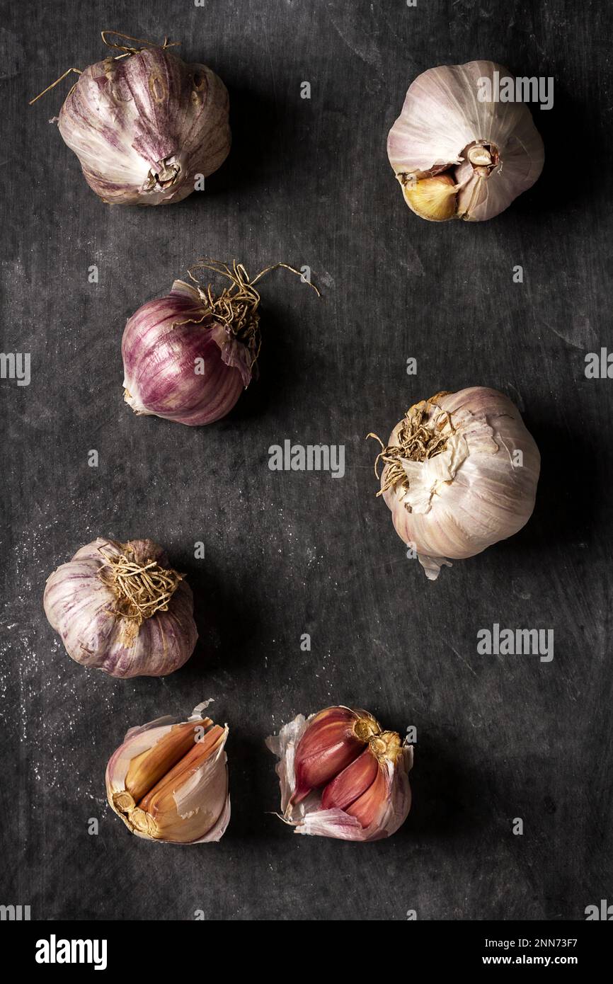 Fresh garlic bulbs and cloves grouped on black background. Flat lay ...