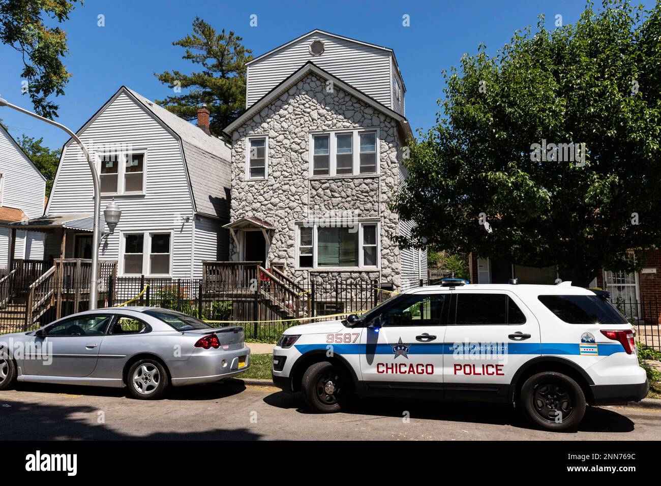Chicago police keep watch and crime scene tape hangs outside a ...