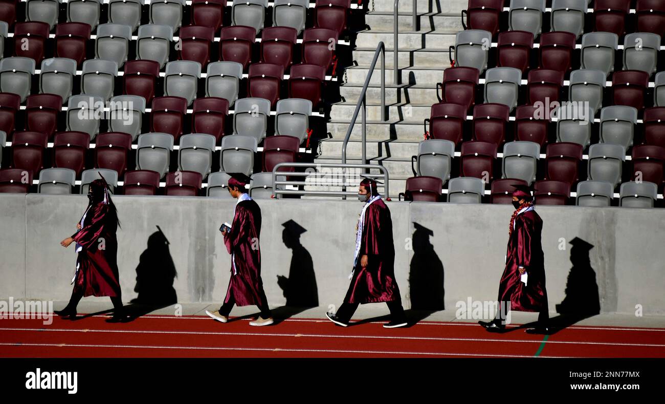 Students and their shadows make their way to the field during the 2021