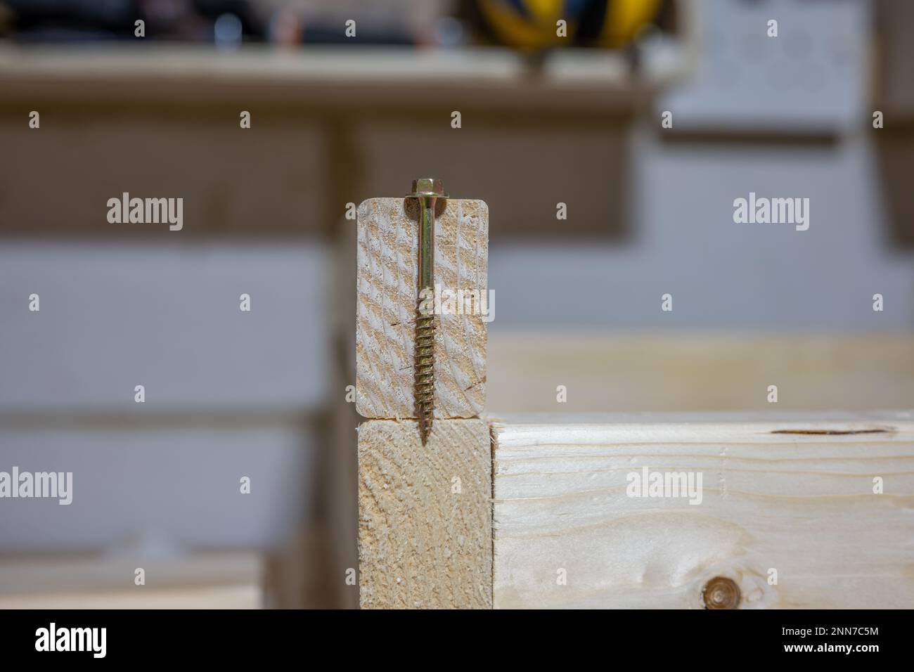 metal coach bolt positioned to test gauge and depth against a sawn