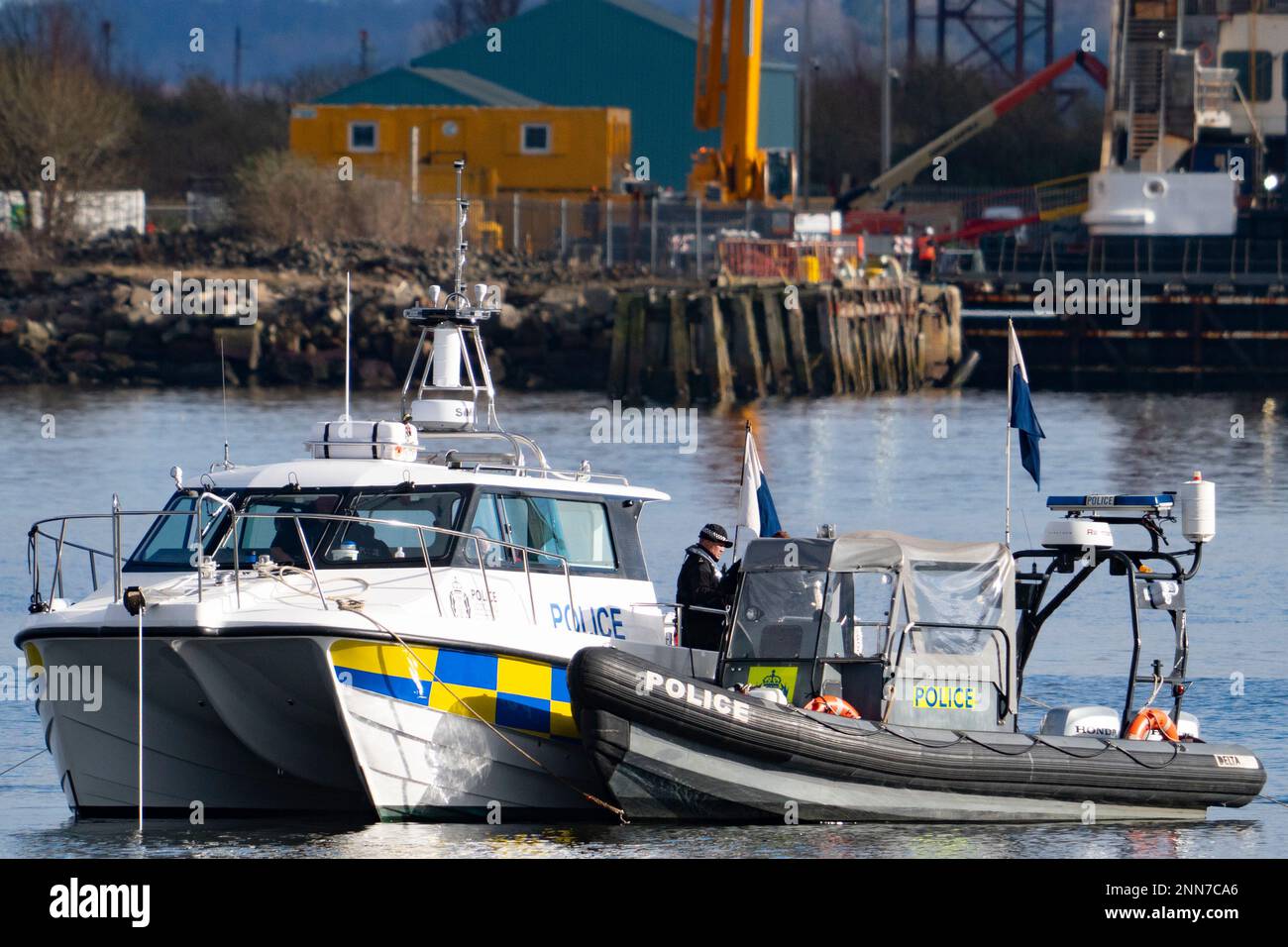 Greenock, Scotland, UK. 25 February 2023. Police and Pilot craft at scene of sinking of the Clyde Marine Services tug Biter that sunk Near East India Harbour in Greenock yesterday .   Two crew members are still missing. Pic; Police divers are working above the sunken tug.  Iain Masterton/Alamy Live News Stock Photo