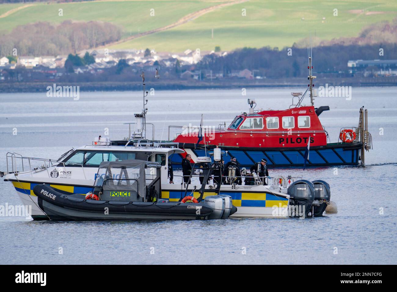 Greenock, Scotland, UK. 25 February 2023. Police and Pilot craft at scene of sinking of the Clyde Marine Services tug Biter that sunk Near East India Harbour in Greenock yesterday .   Two crew members are still missing. Pic; Police divers are working above the sunken tug.  Iain Masterton/Alamy Live News Stock Photo
