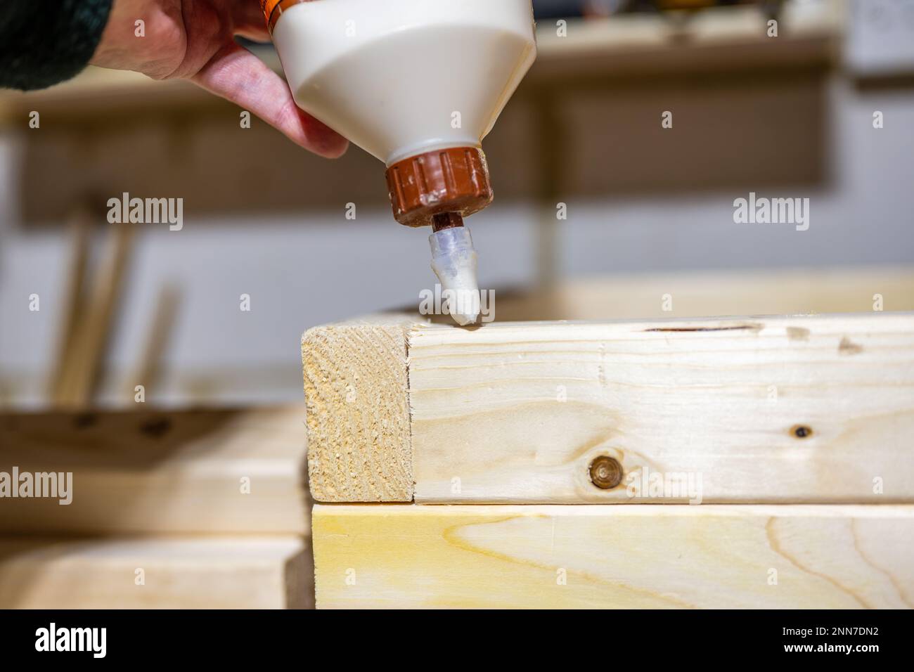 applying wood glue to the bed joint of a timber lumber planter box in