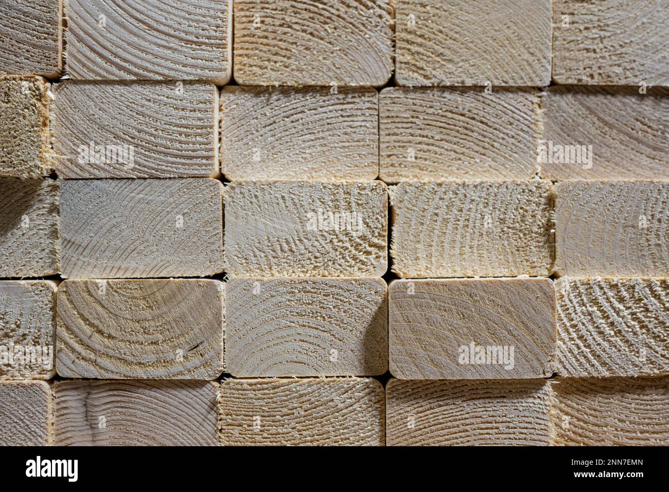 background of a Neat stacked pile of sawn lumber timber showing end