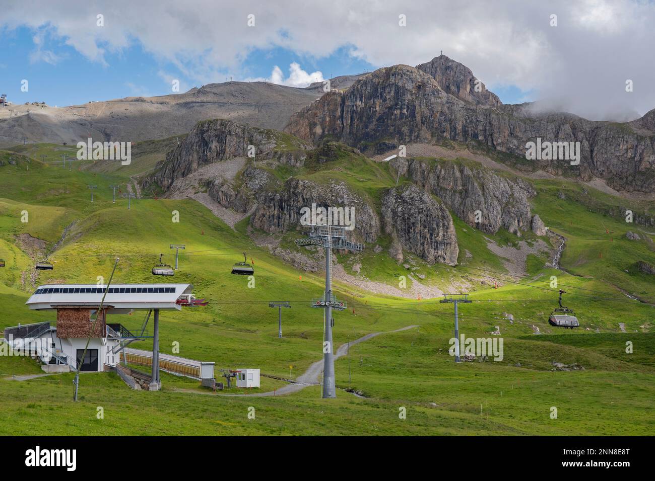 Summer in the Silvretta Arena in Ischgl. With chairlifts at the Idalp and the high rock formations. You can see the yellow snow cannons in the background. Stock Photo