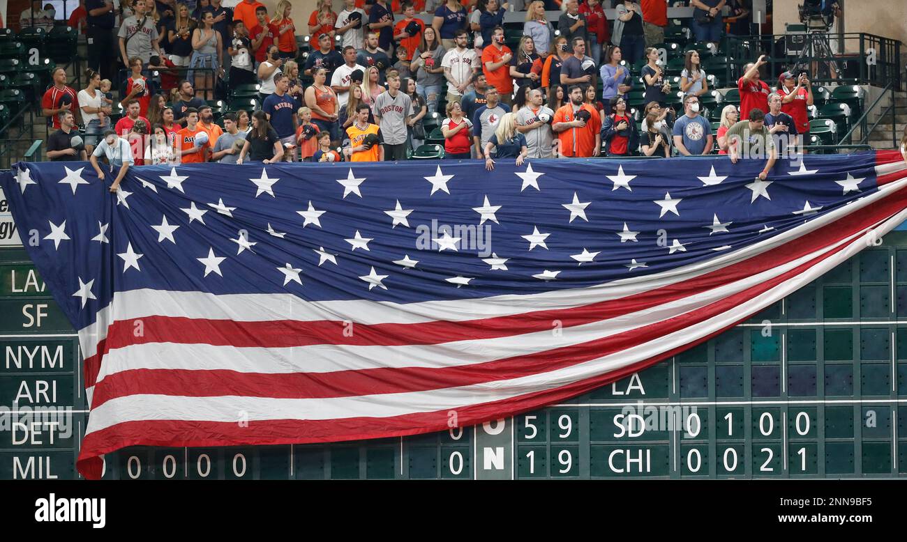 Houston Astros employees lower a giant United States flag over the  scoreboard under the Crawford Boxes during the national anthem before a  baseball game against the Boston Red Sox, Monday, May 31,