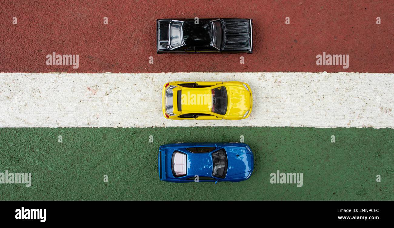 A photo of 3 toy cars placed at the edge of the court line, after ...