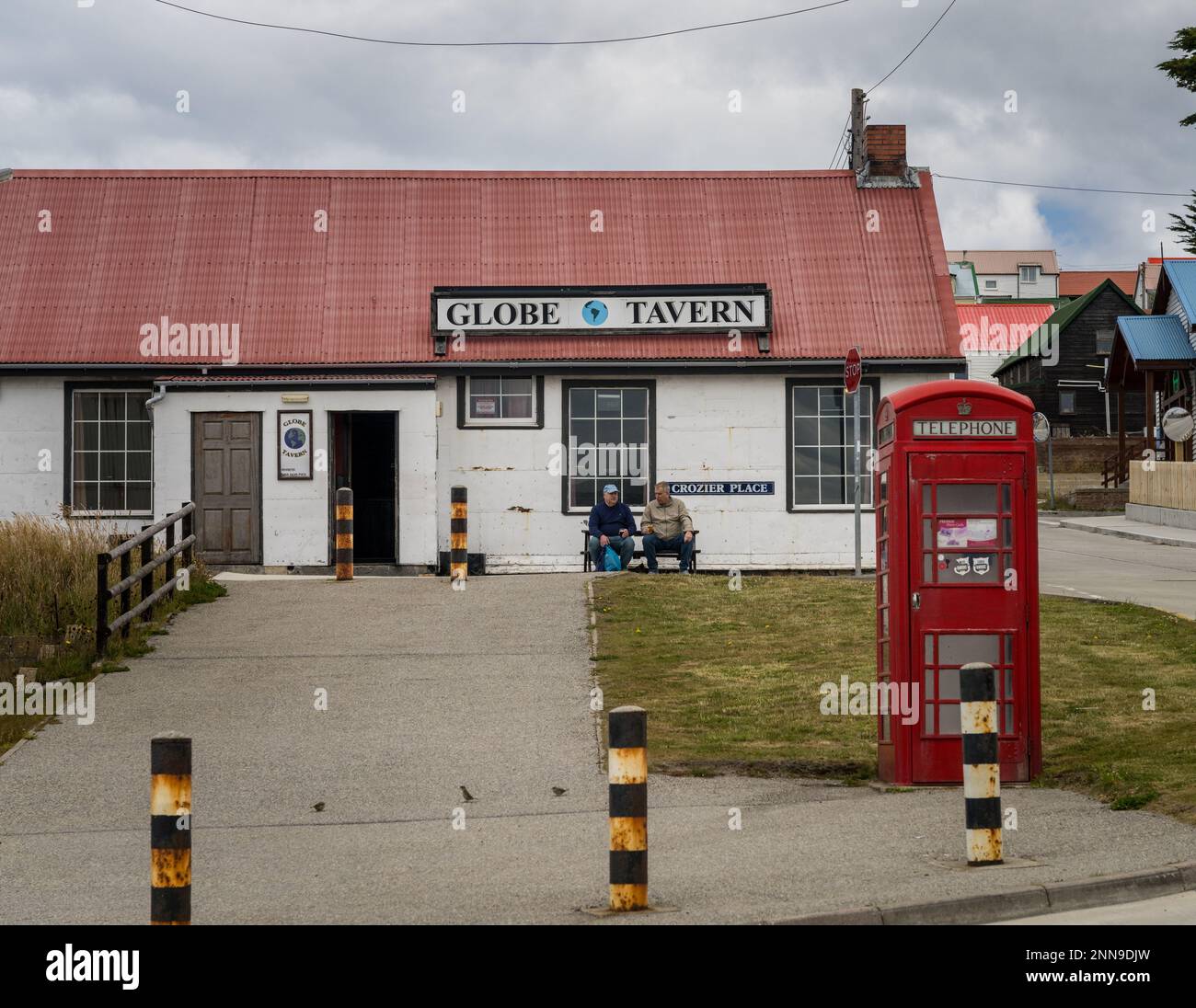 Port Stanley, Falkland Islands - 31 January 2023: Two tourists with beer outside the Globe Tavern Stock Photo