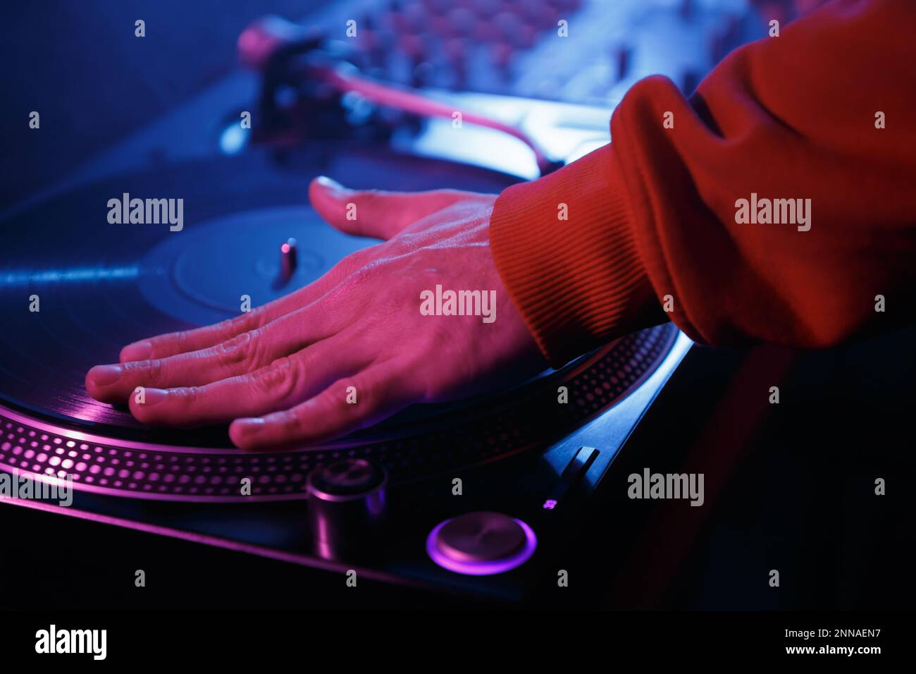 Hip hop DJ scratching records on turntables. Club disk jokey scratches