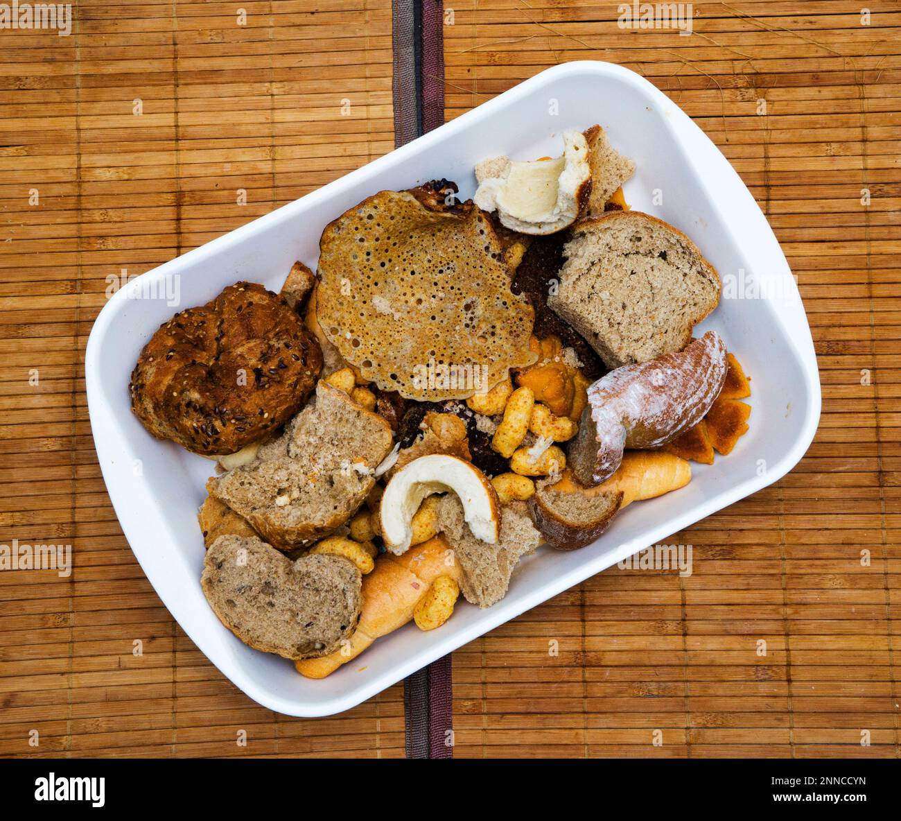 Pile of many slices of stale bread and other stale baked goods. Tossing breads and buying too much bread without the need. Or stocks of rusks for a po Stock Photo