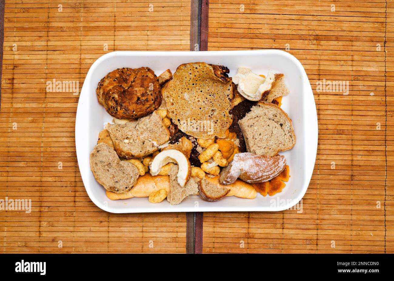 Pile of many slices of stale bread and other stale baked goods. Tossing breads and buying too much bread without the need. Or stocks of rusks for a po Stock Photo