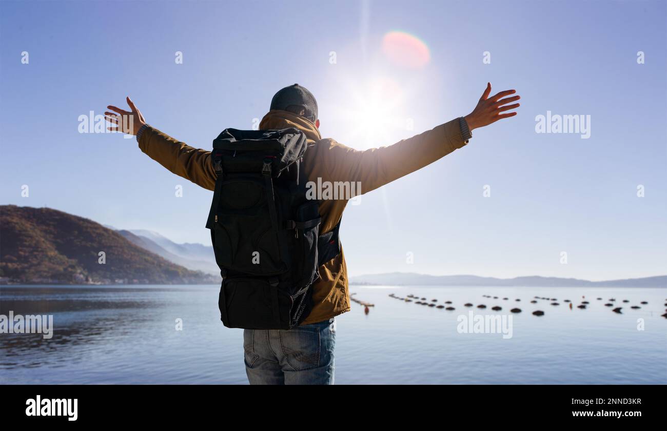 A traveler with a backpack holds his hands to the sides Stock Photo