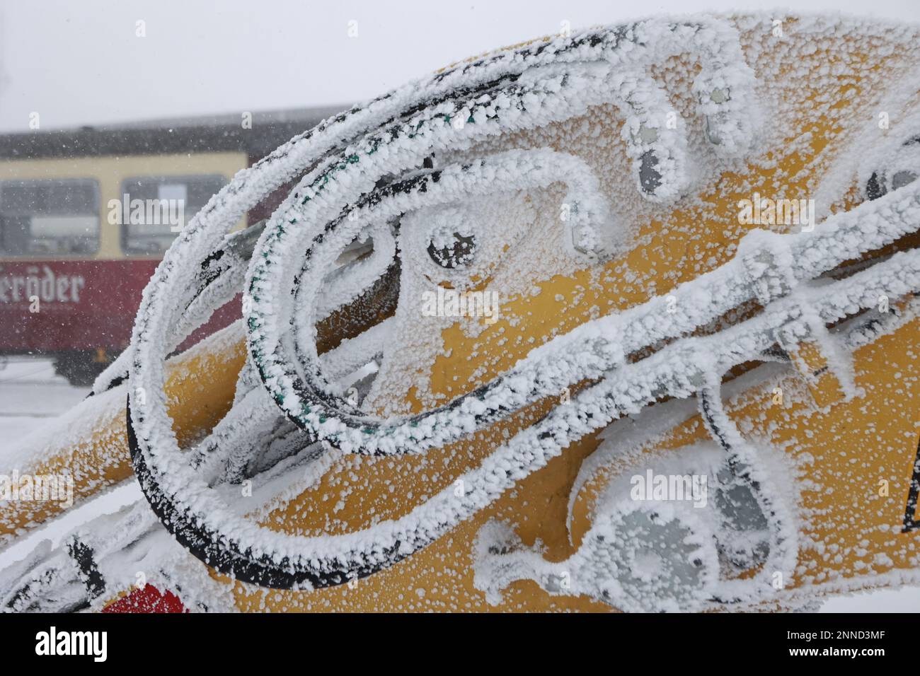 Schierke, Germany. 25th Feb, 2023. Ice deposits cover the grab arm of an excavator on the