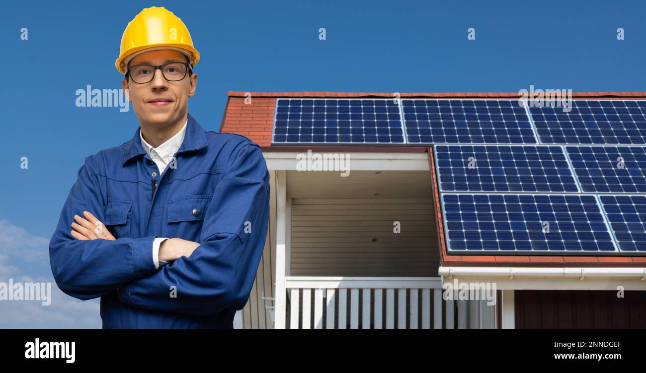 Engineer on a background of house roof with solar panels Stock Photo