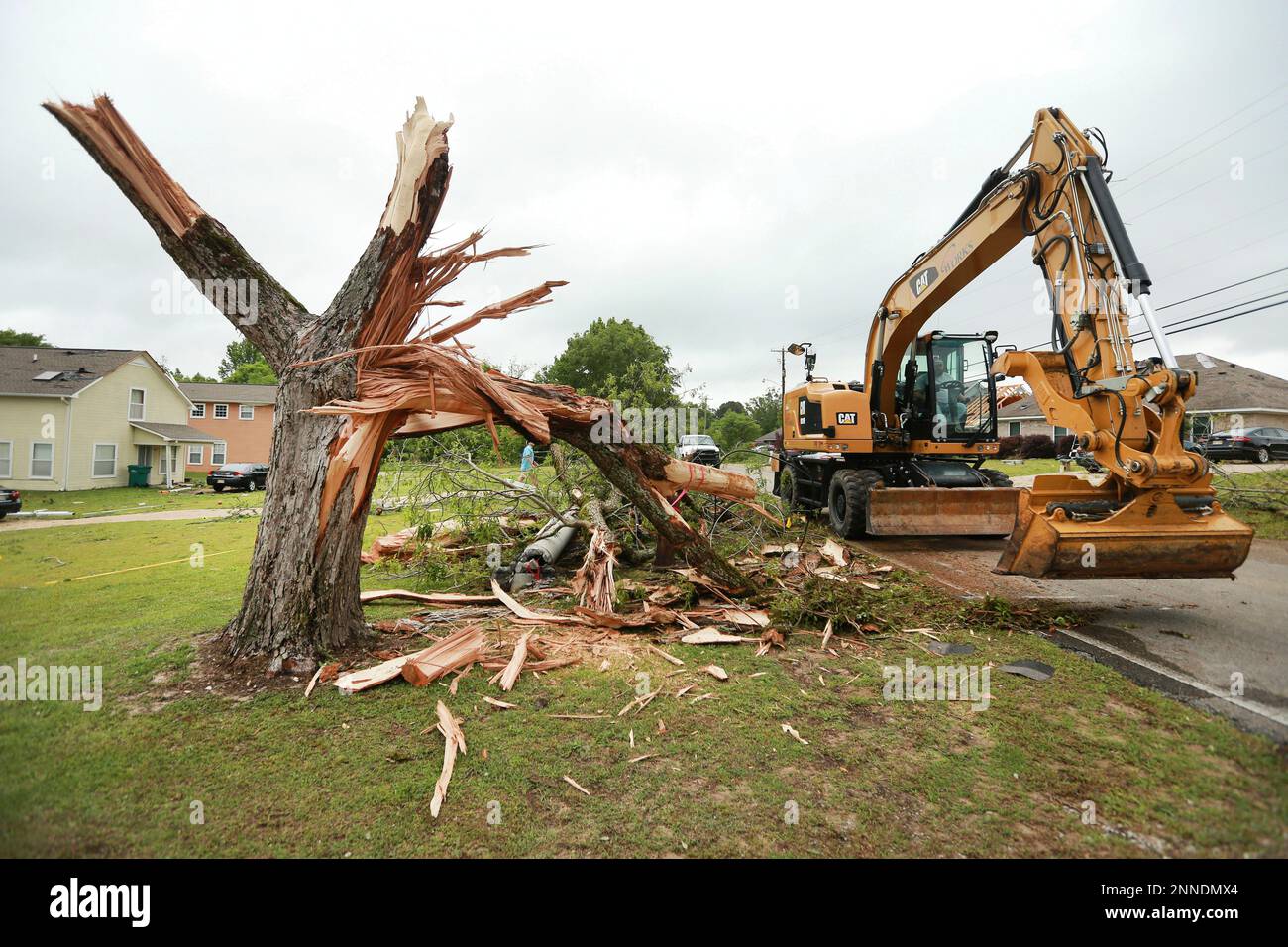 A Tupelo Public Works employee works to clear out more debris and tree ...