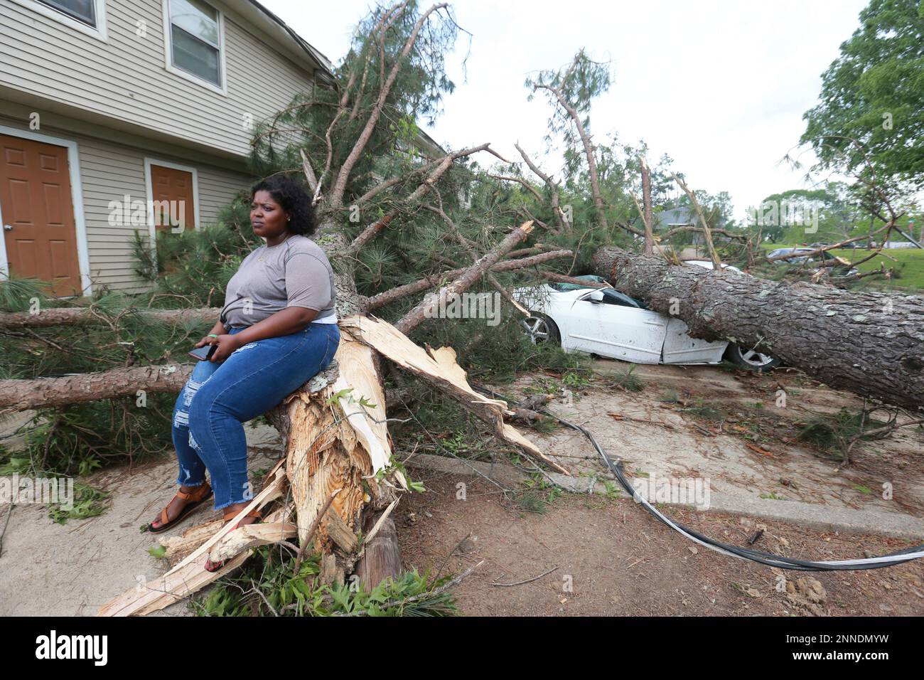 Myesha Gore of Calhoun City, Miss., sits on the trunk of a shattered