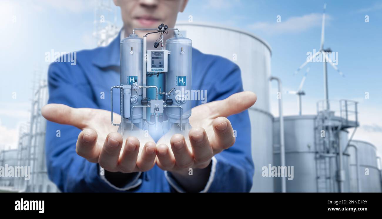 Development engineer holds in his hands a model of machine for the production of hydrogen by electrolysis created in augmented reality. Stock Photo