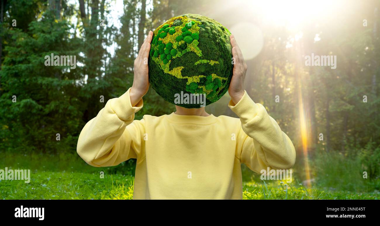 Woman holds a green planet Earth. Symbol of sustainable development and renewable energy Stock Photo