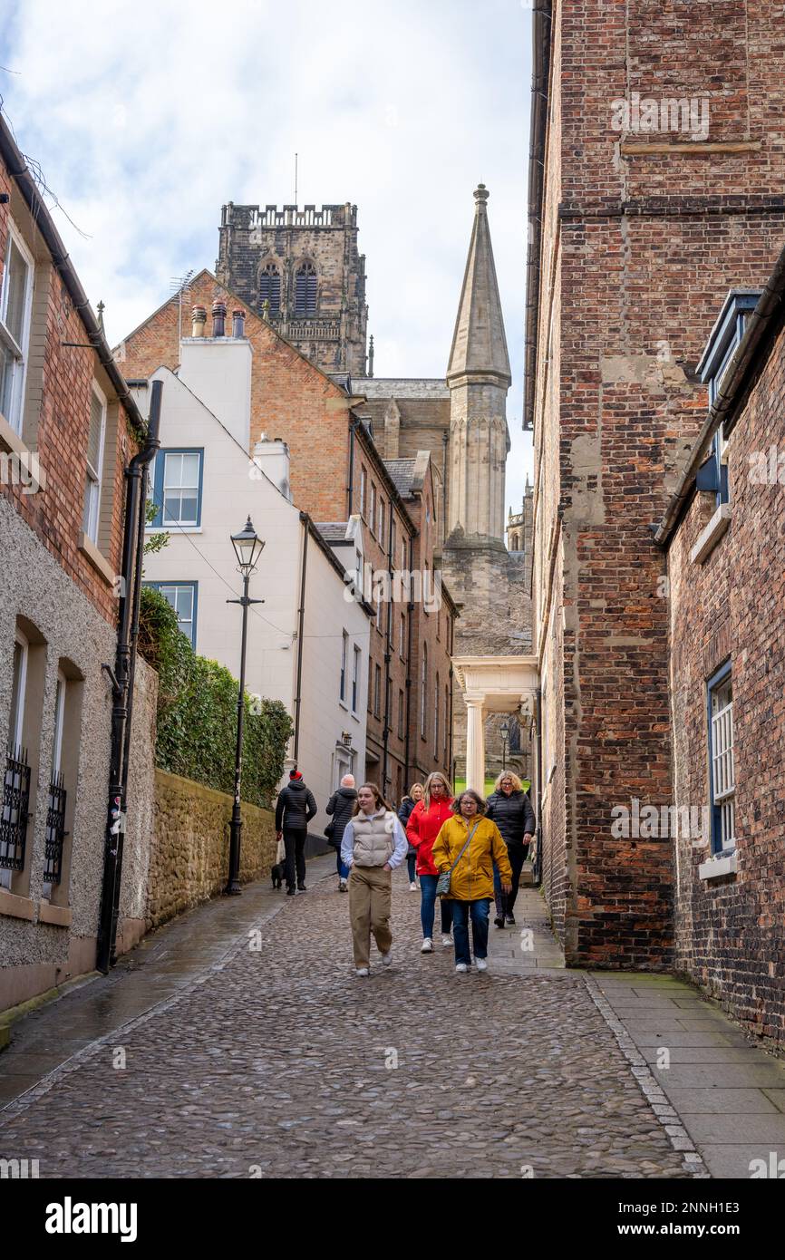 Visitors walk on a cobbled lane near Durham Cathedral, a UNESCO World Heritage Site in the city of Durham, UK Stock Photo