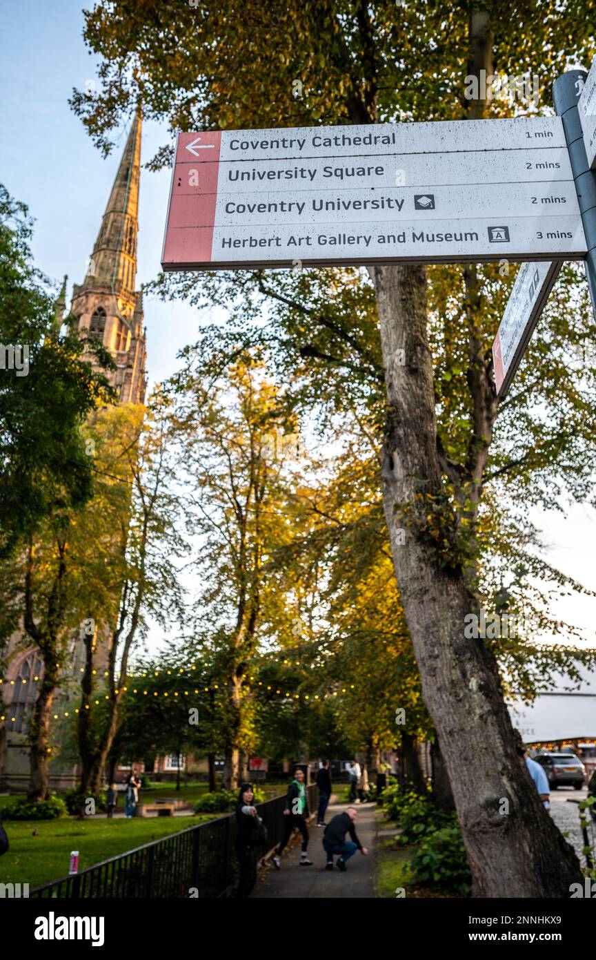 Holy Trinity Church spire with tall trees in front at Coventry West