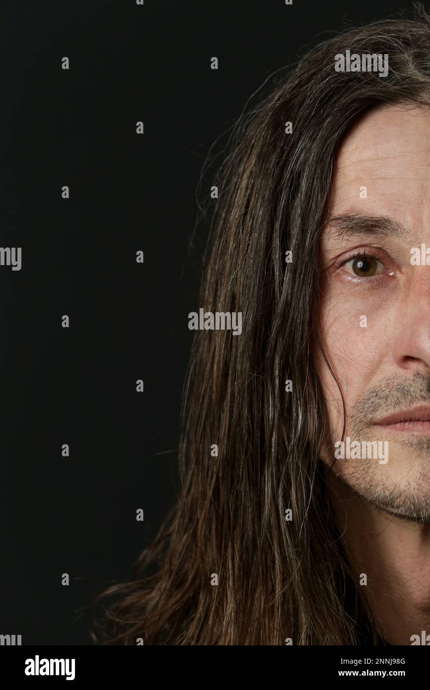 Portrait of middle aged man with long hair on black background Stock ...