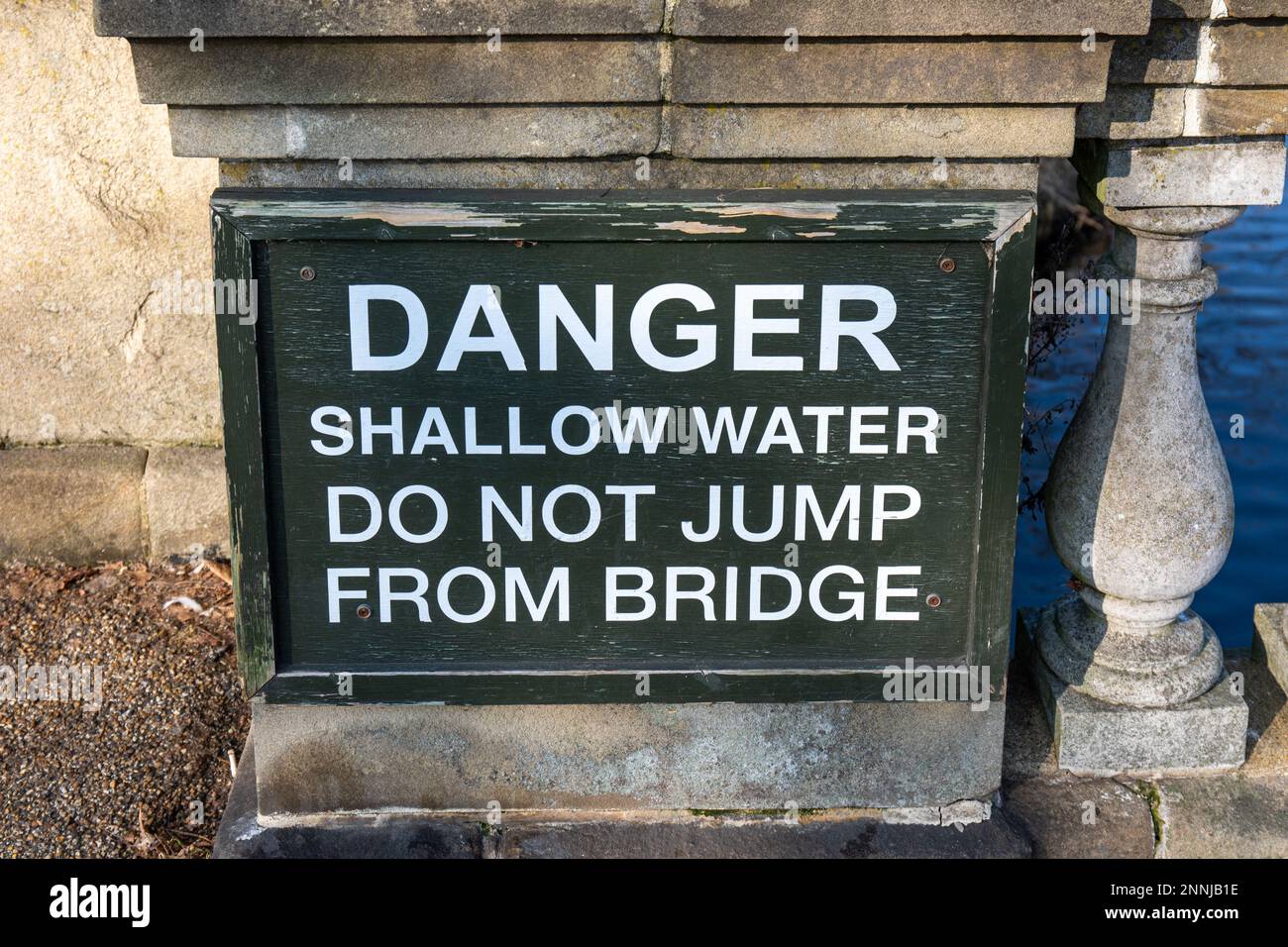 Danger. Shallow water. Do not jump from the bridge. Warning sign on Serpentine Bridge dividing Hyde Park and Kensington Gardens in London, England. Stock Photo
