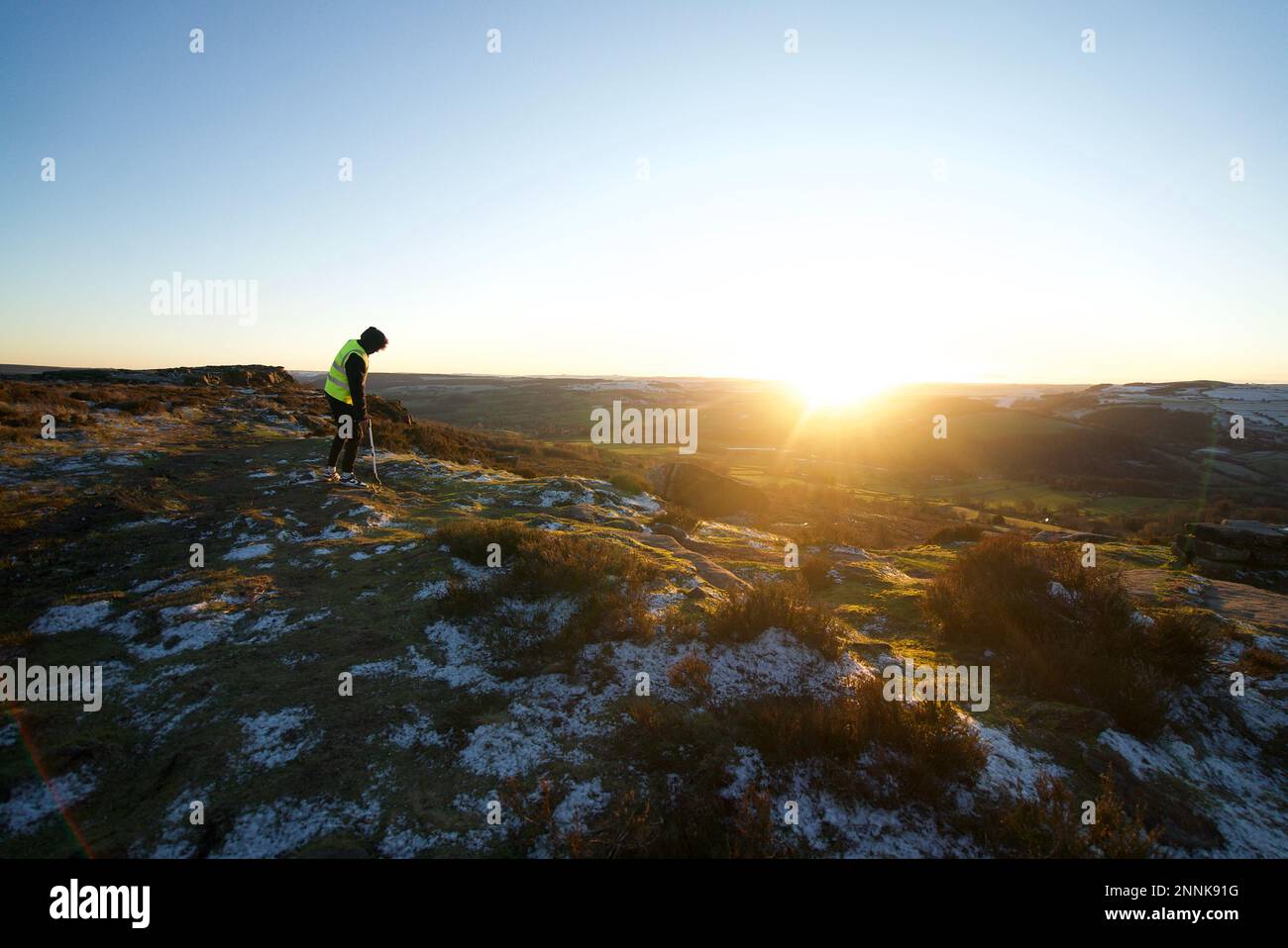 A man picking up litter in the Peak District, along Baslow Edge at