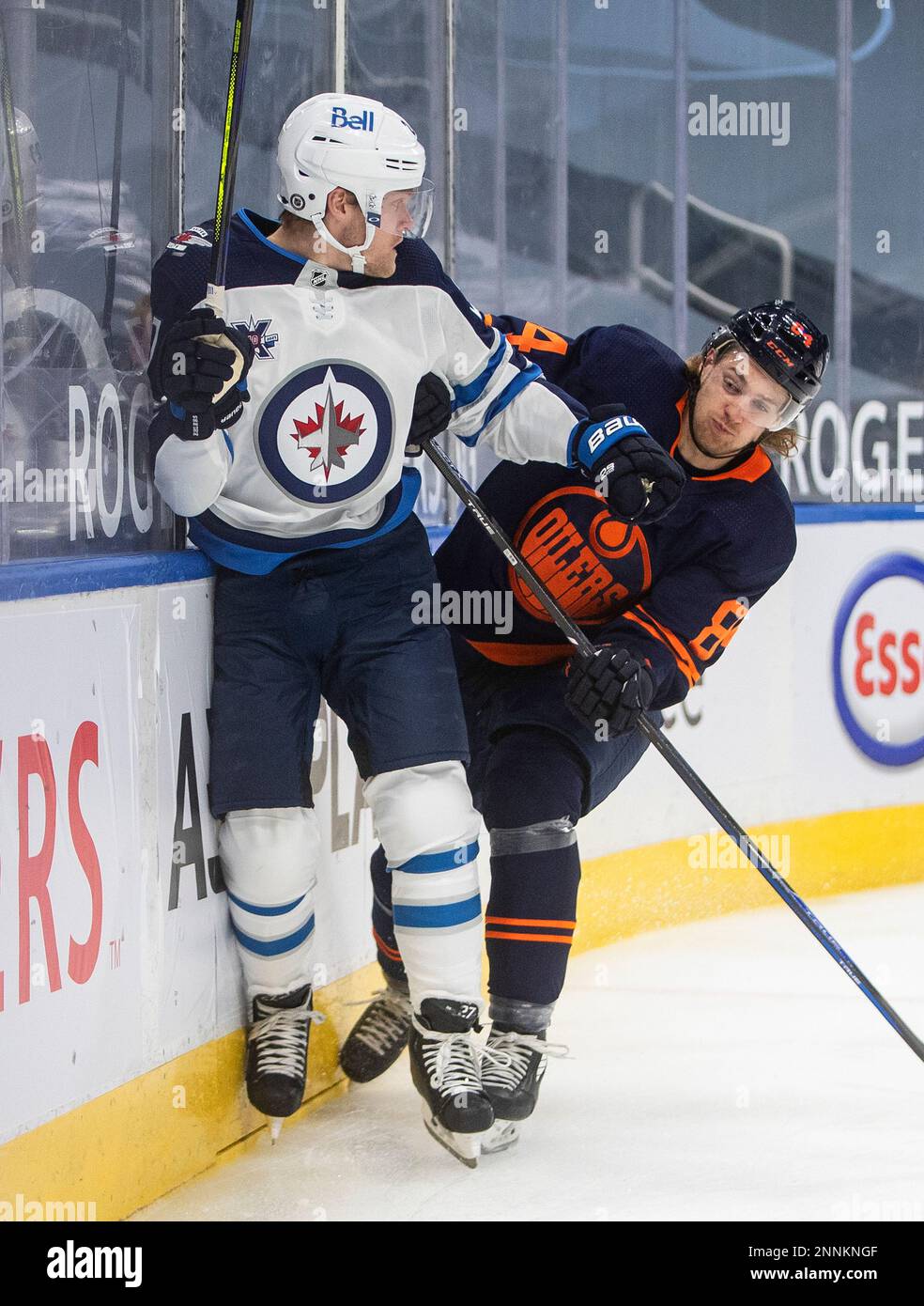 Edmonton Oilers' William Lagesson (84) checks Winnipeg Jets