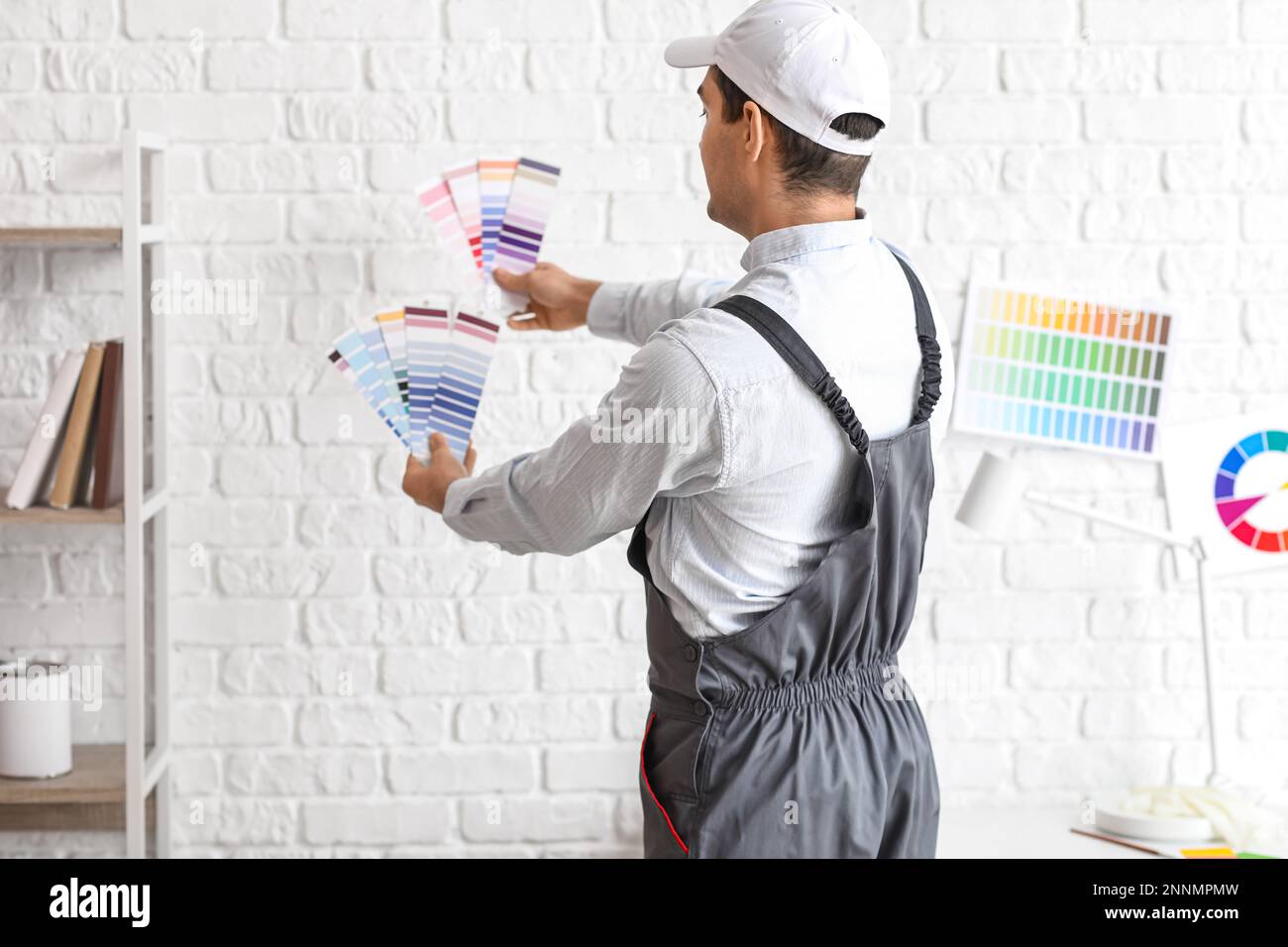 Male painter with color palettes near white brick wall Stock Photo Alamy