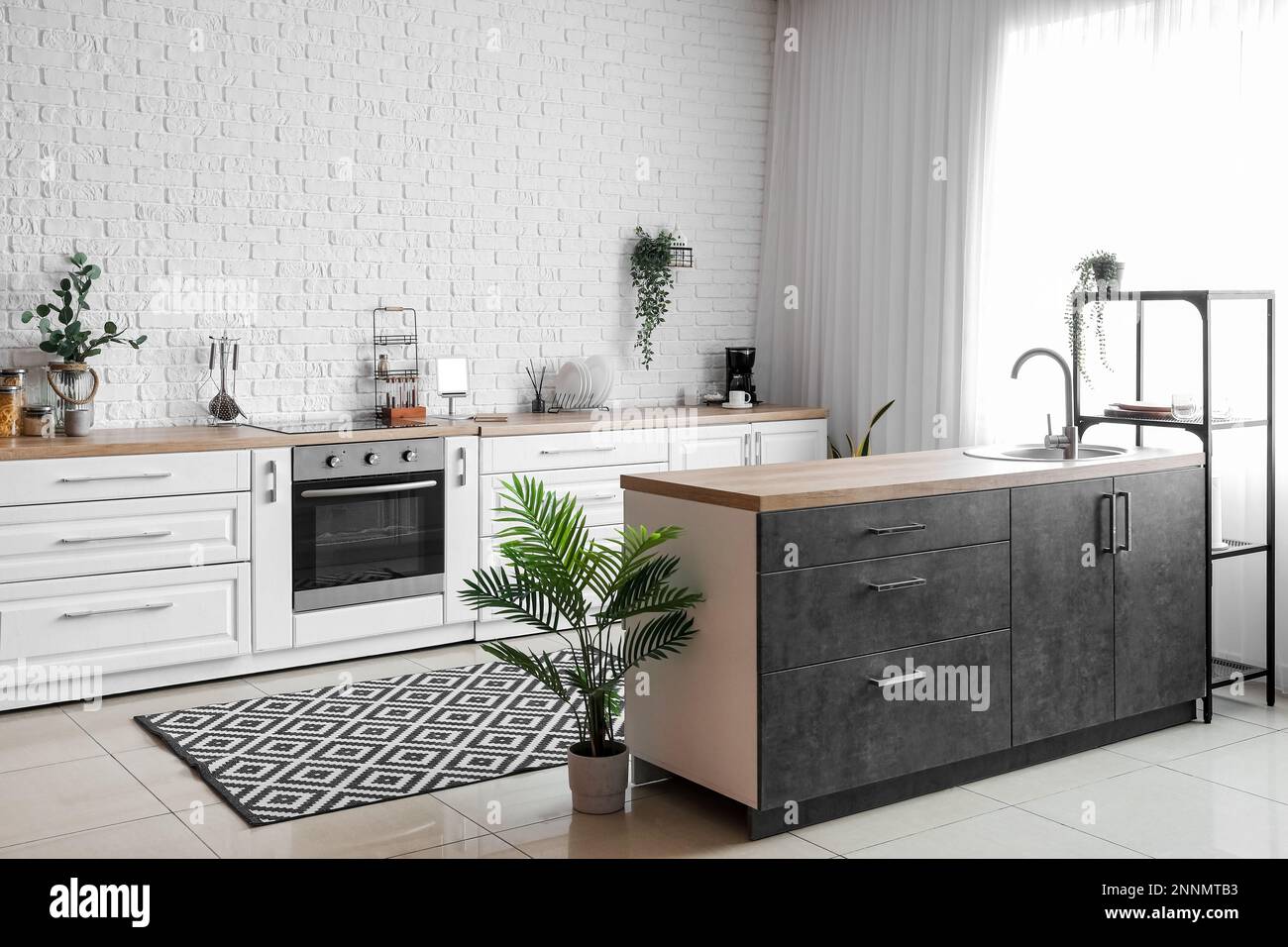 Interior of light kitchen with white counters, electric oven and ...