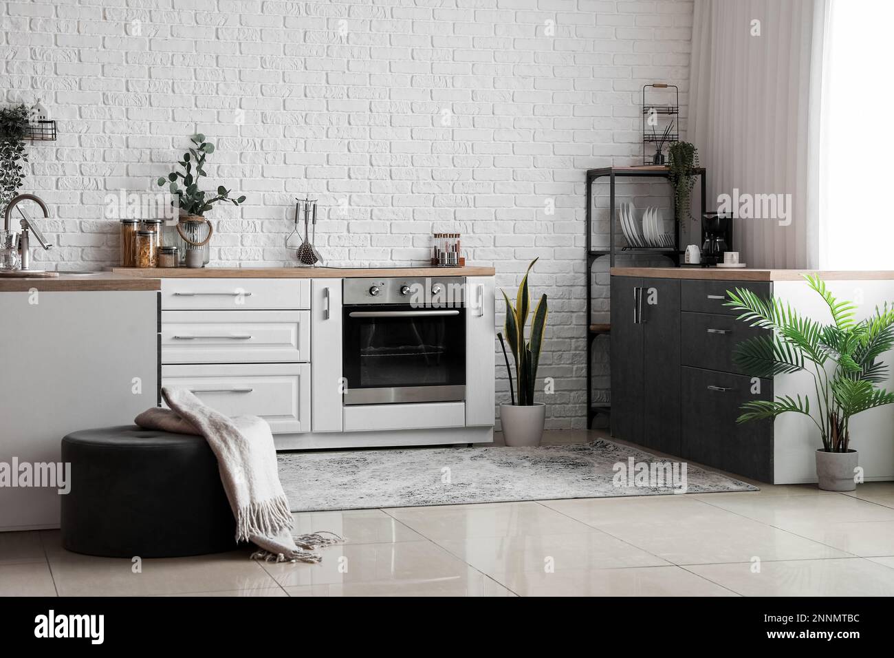 Interior of light kitchen with white counters, electric oven and ...