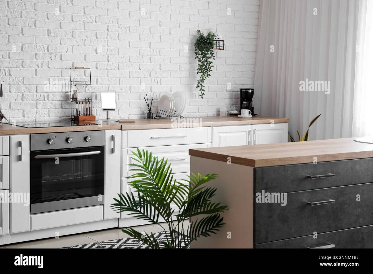 Interior of light kitchen with white counters, electric oven and ...