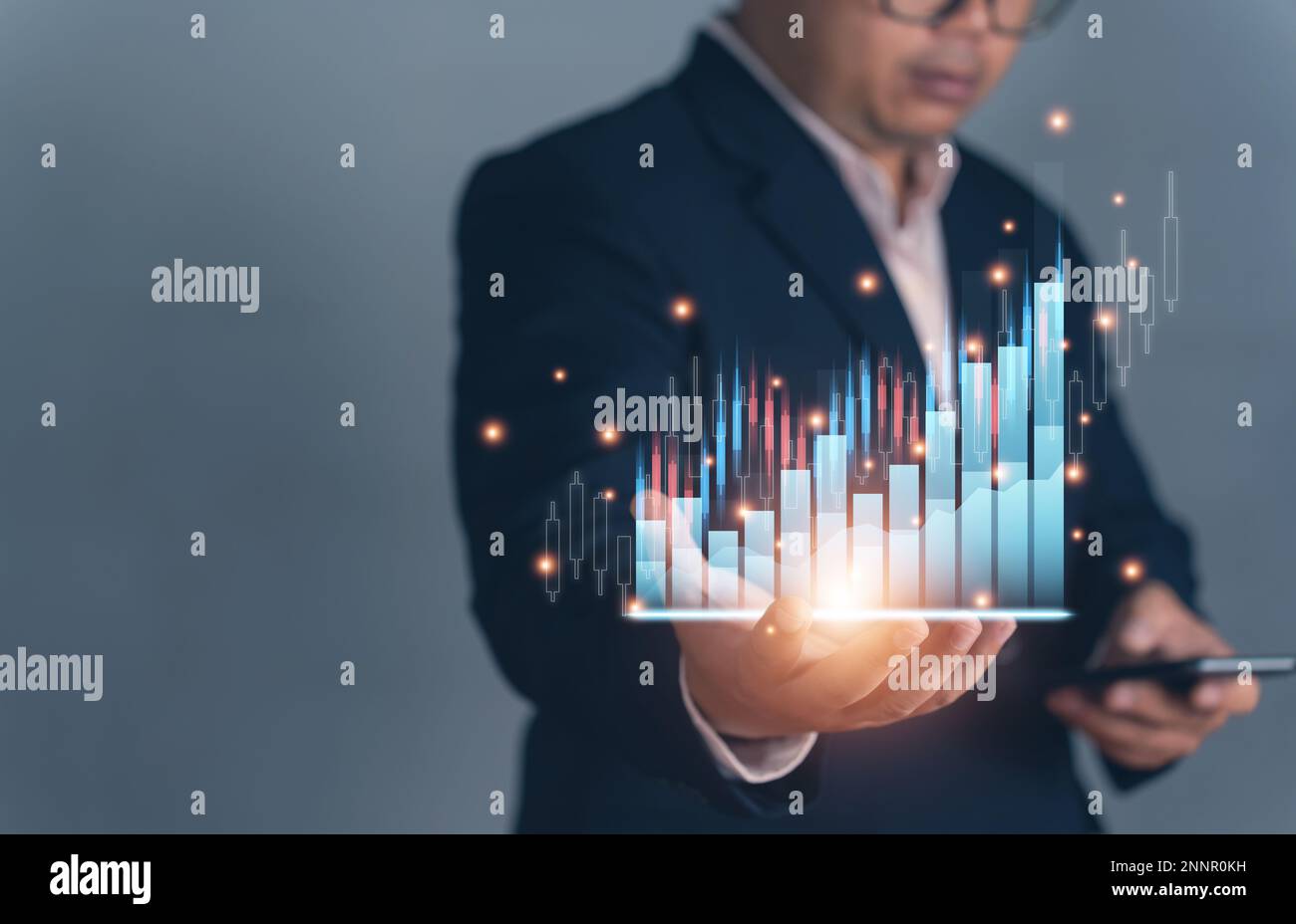 business man showing a growing virtual hologram of statistics on hand. Graph and chart with arrow growth up on business hand. Stock market. Business g Stock Photo