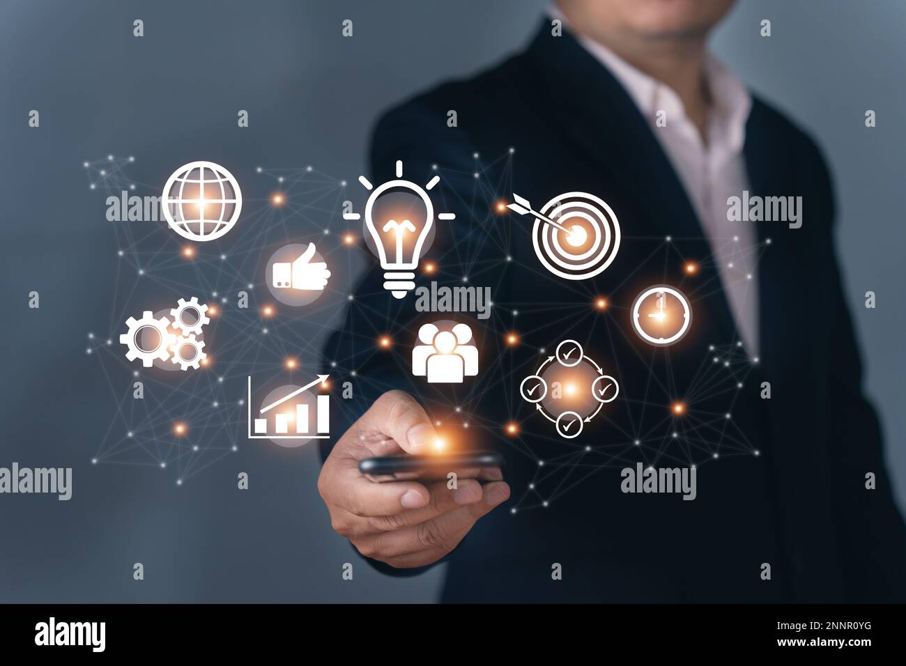 Businessman holding business elements icons on screen. Technology and strategy Stock Photo