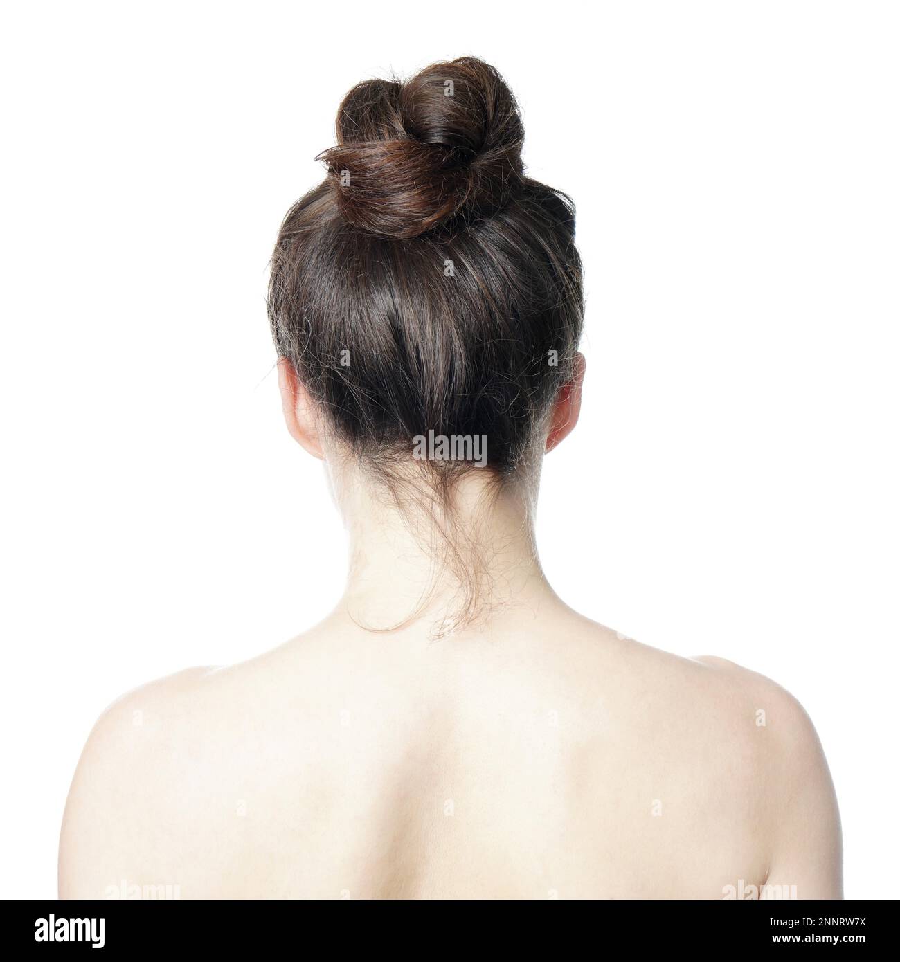 head and shoulder back view of young woman with messy bun - undone hair style fashion trend Stock Photo