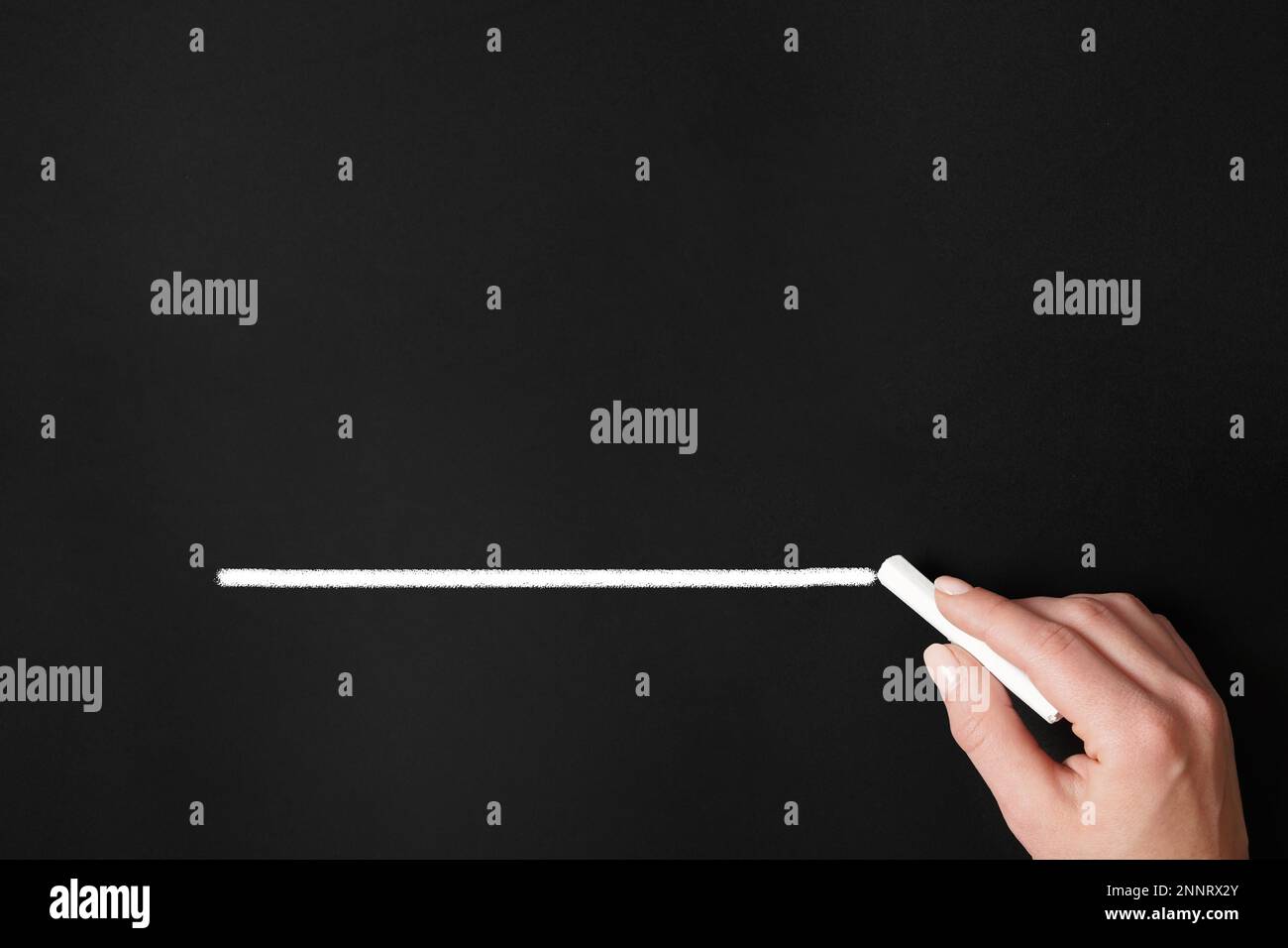 female hand drawing chalk line on chalkboard blackboard background with copy space Stock Photo