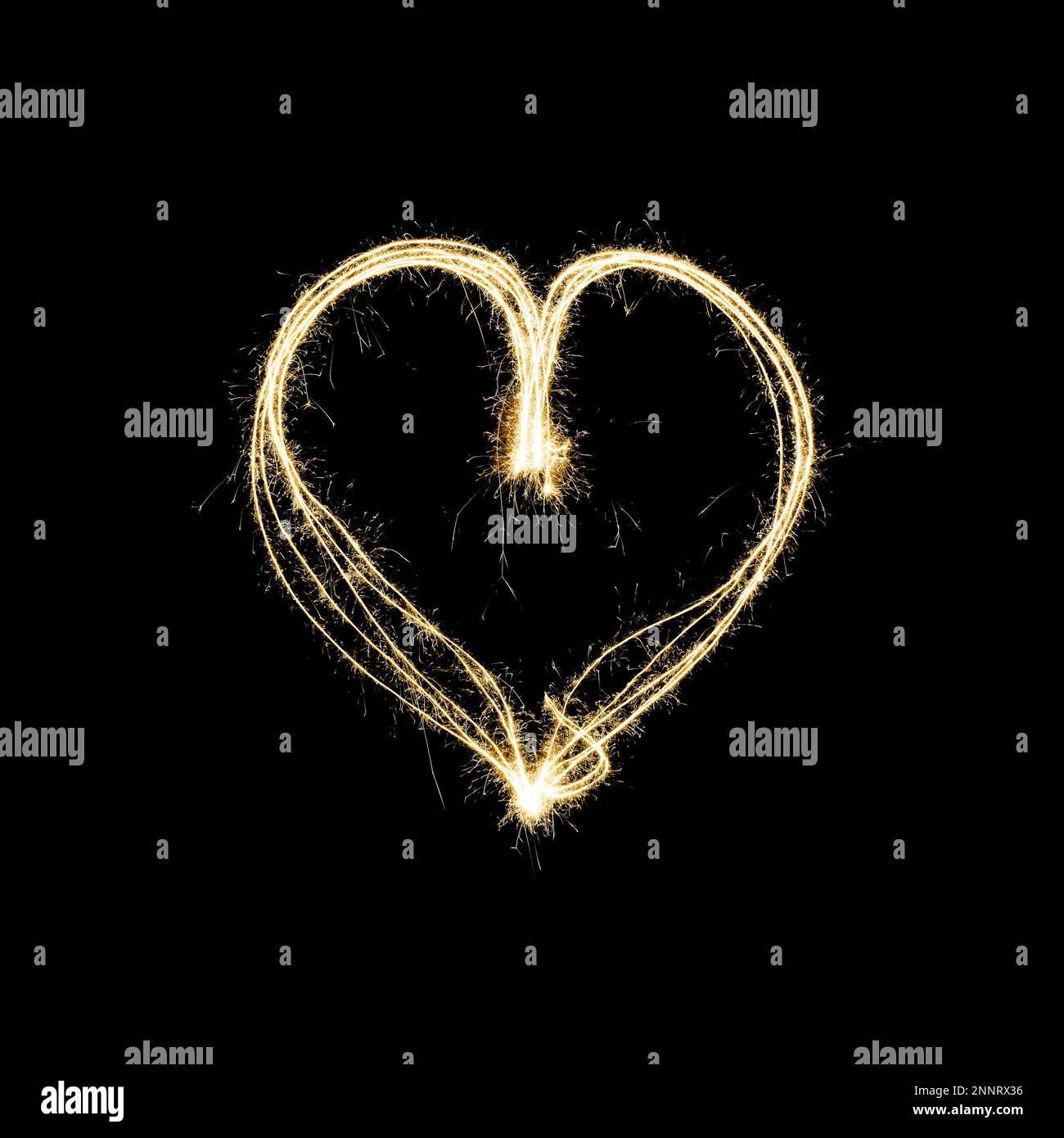 heart shape light painting with sparklers isolated on black background - symbol for love and romance Stock Photo
