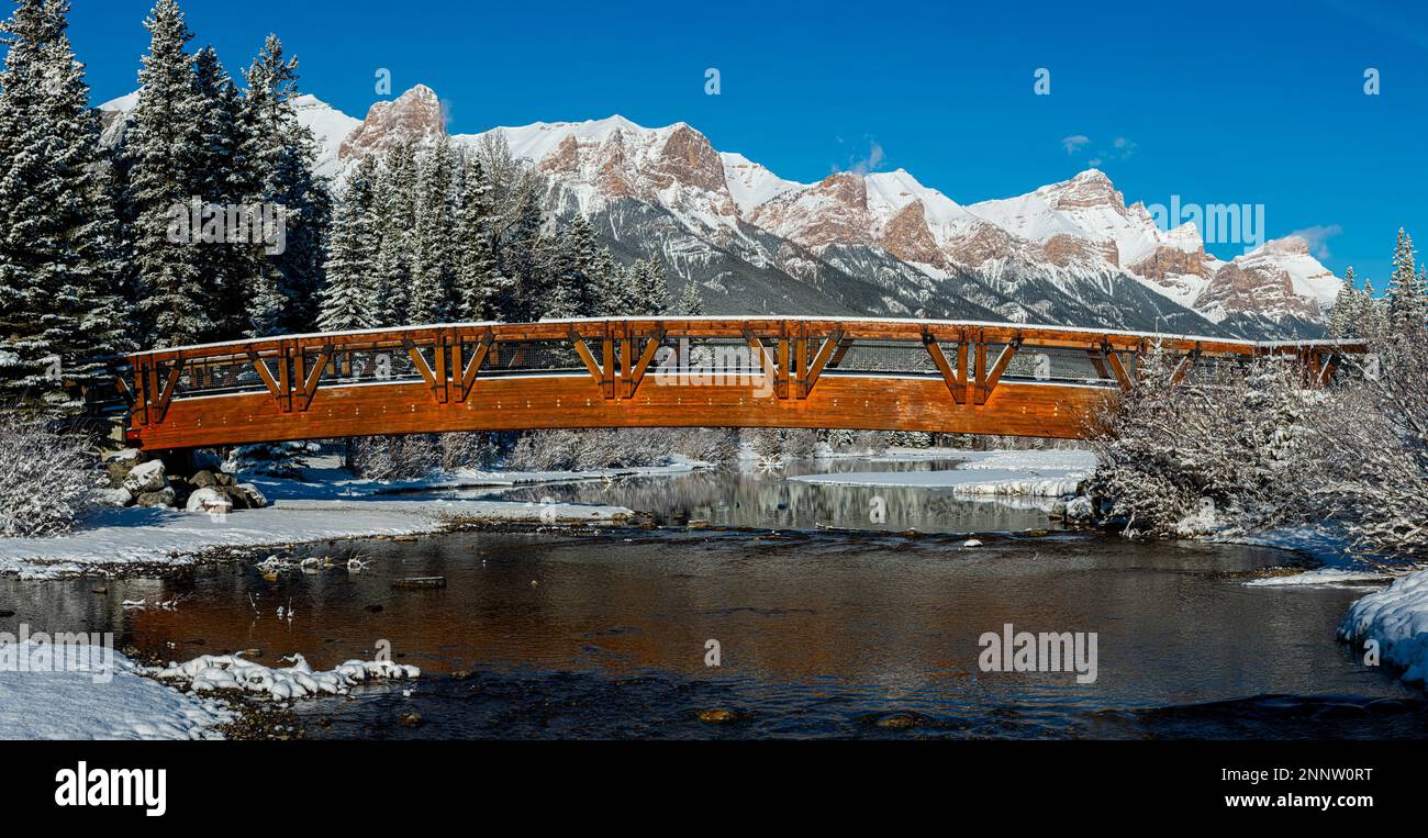 Footbridge over Policemans Creek in snowy mountain landscape with Mount ...