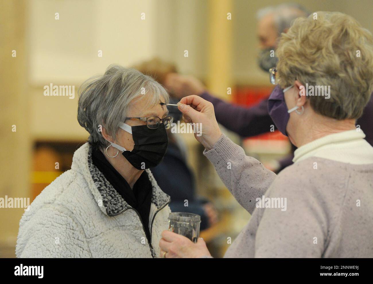 Eucharistic Minister Maureen Pantucci traces the sign of the Cross