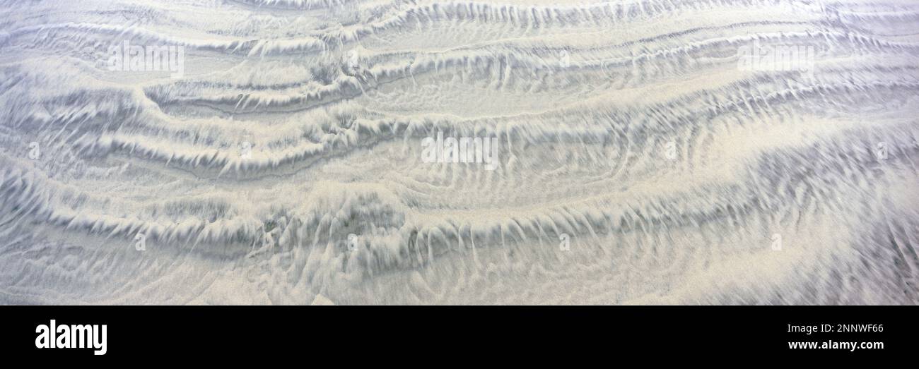 Sand patterns created by receding tide Stock Photo