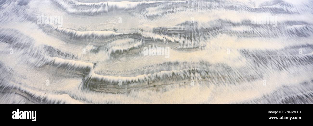 Sand patterns created by receding tide Stock Photo