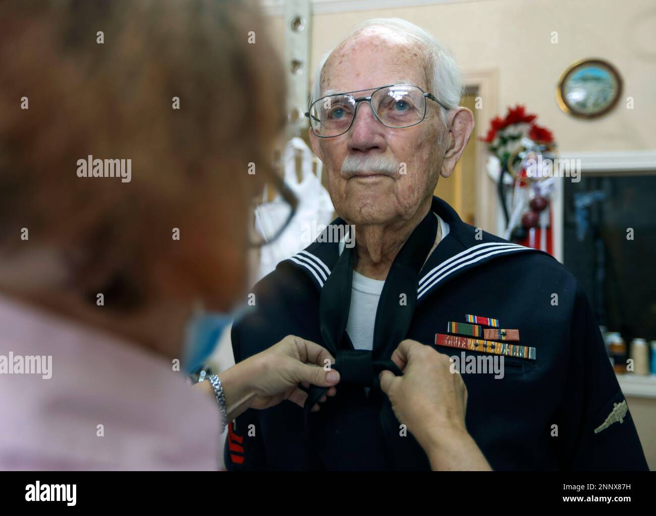 Joseph Hall, 96, of Dunedin, right, holds still as seamstress Susan