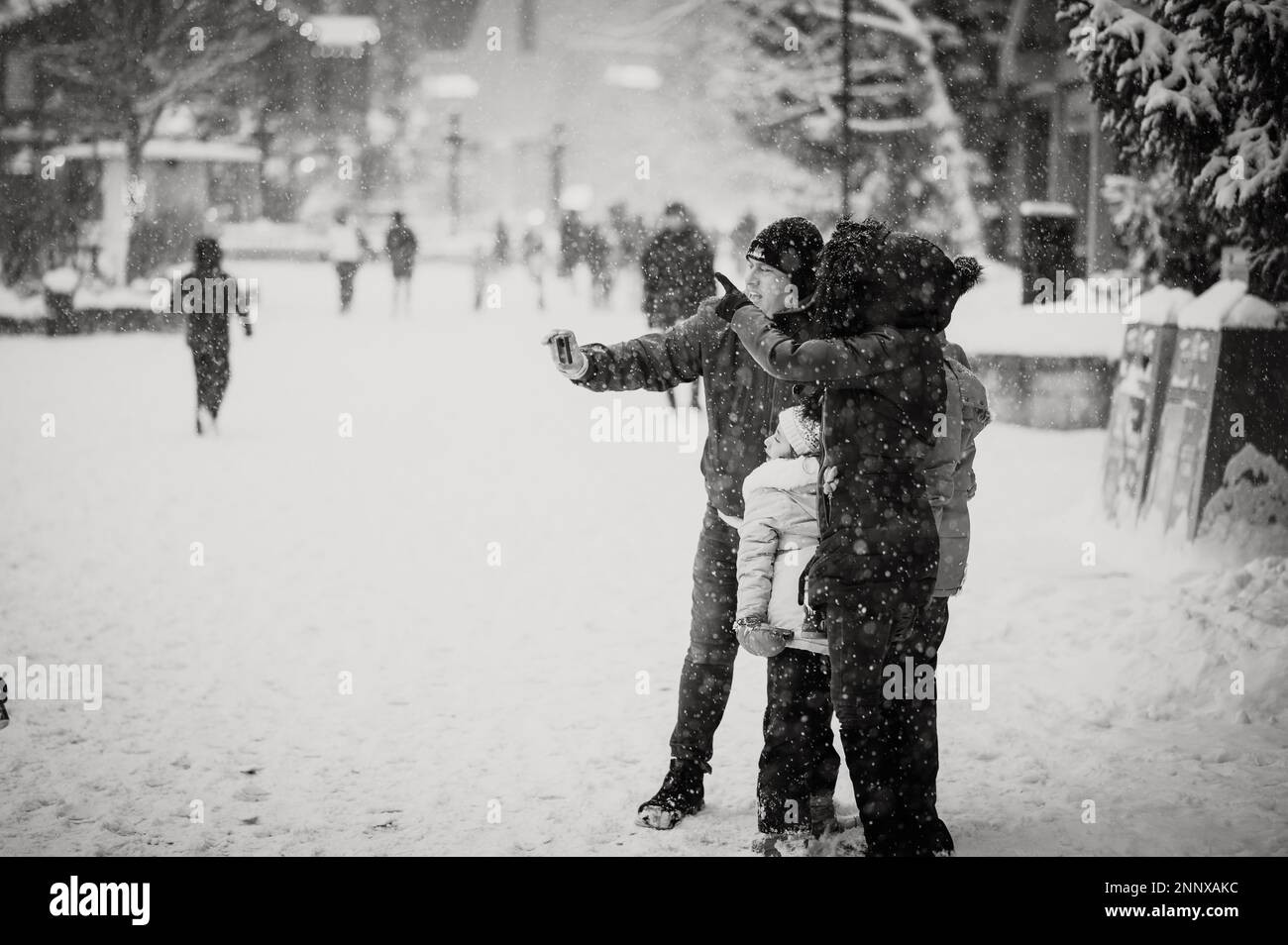 Black and white photo of Whistler tourists on a snowy afternoon in the winter.  Whistler BC, Canada. Stock Photo