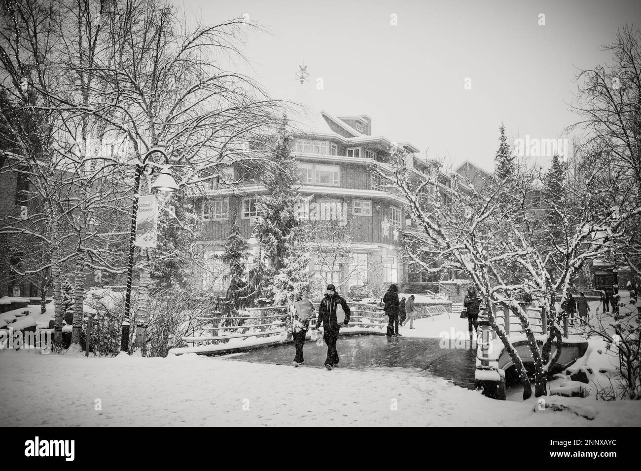 Black and white photo of Whistler tourists on a snowy afternoon in the winter.  Whistler BC, Canada. Stock Photo