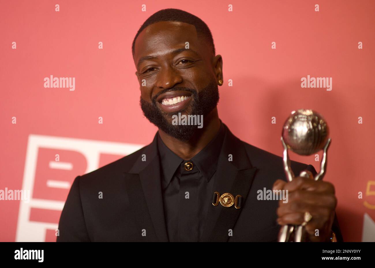 Dwyane Wade poses with the president's award in the press room at the