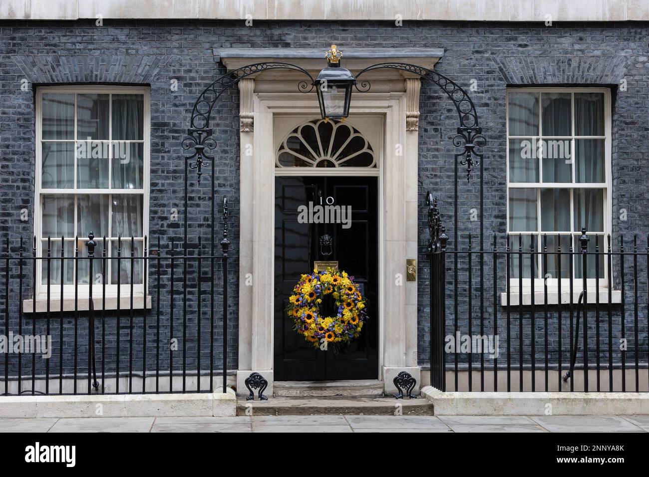 London, UK. 24th Feb, 2023. A wreath decorated with sunflowers, the national flower of Ukraine, hangs on the door of 10 Downing Street in London. The world is marking the one-year anniversary of the full-scale Russian invasion of Ukraine. Credit: SOPA Images Limited/Alamy Live News Stock Photo