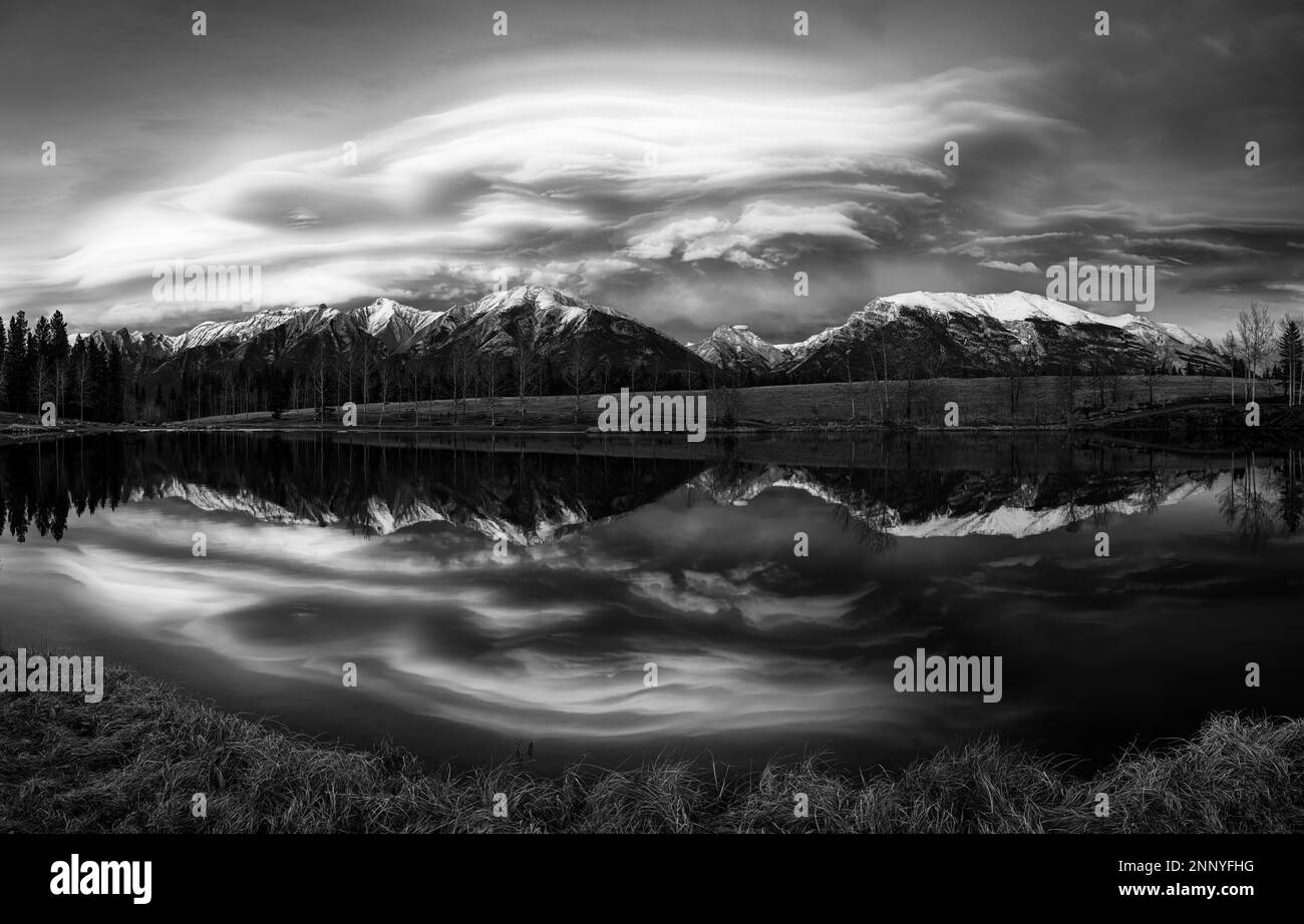 Chinook clouds over Grotto Mountain reflected in Quarry Lake at sunset, Canmore, Alberta, Canada Stock Photo