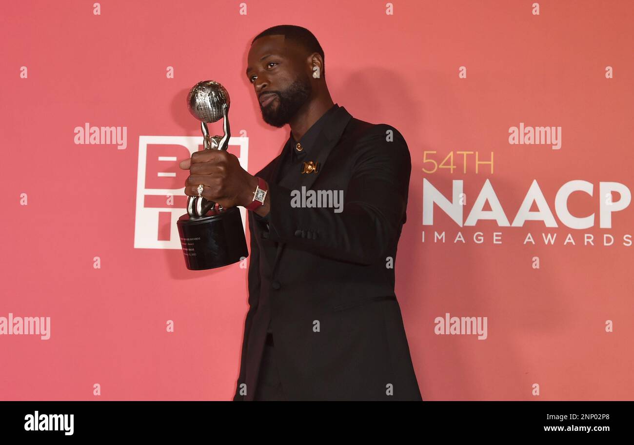 Dwyane Wade poses with the president's award in the press room at the