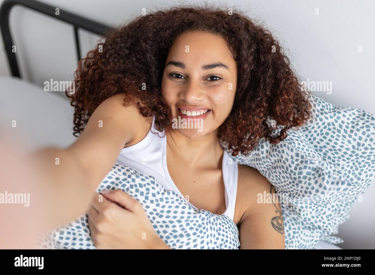 Cheerful young adult latin american woman taking selfie while resting on  bed Stock Photo - Alamy, image size:1300x956
