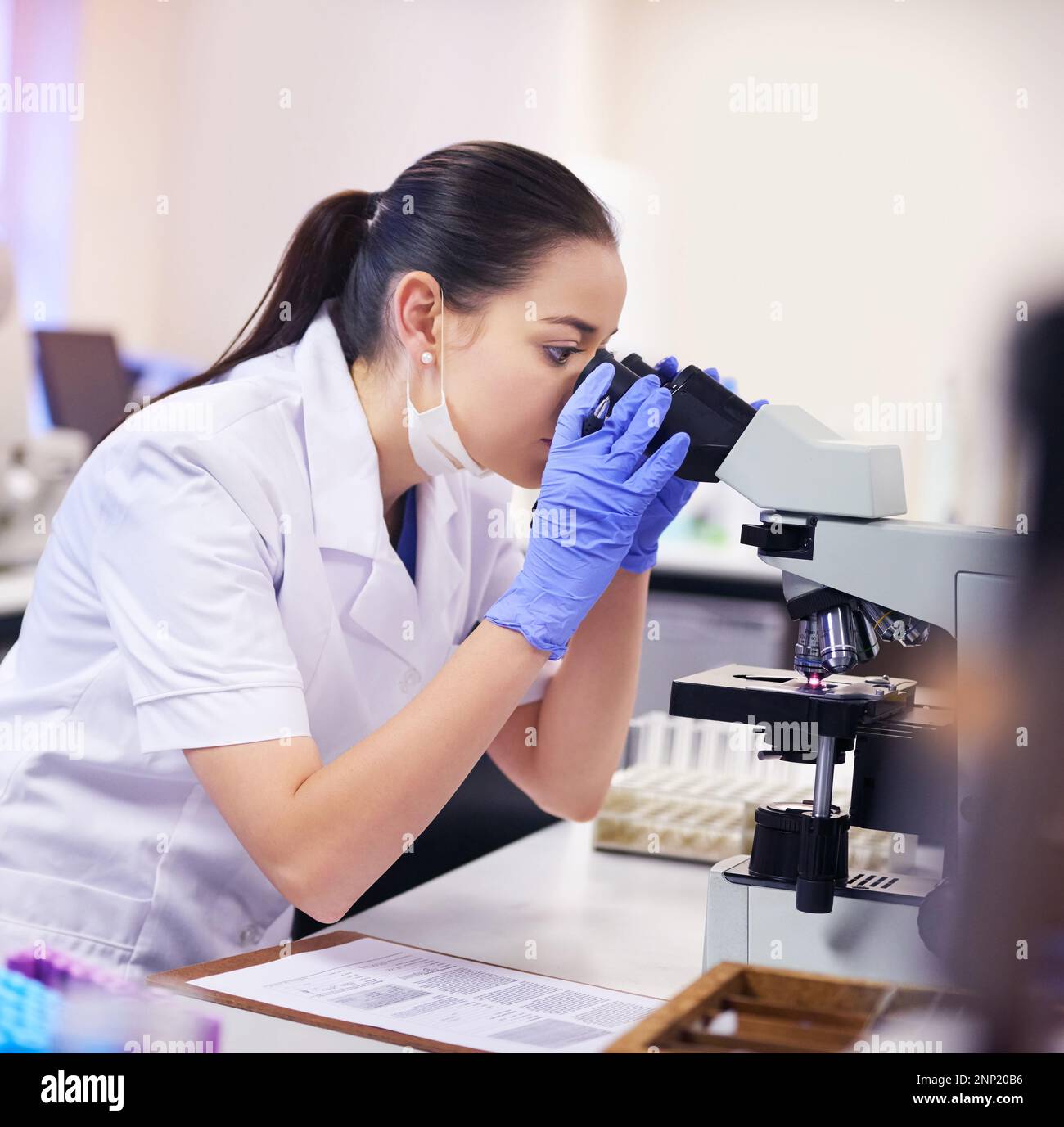 Nothing escapes her eye. a young scientist using a microscope in a ...